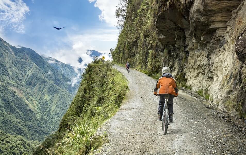 Dos personas haciendo cicloturismo en las montañas en Bolivia